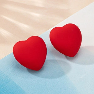 Orecchini a perno a cuore rosso opaco 3D su sfondo minimalista blu e beige con riflessi