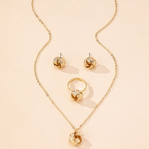 Detailed view of gold twisted rope knot jewelry set including necklace, studs, and ring