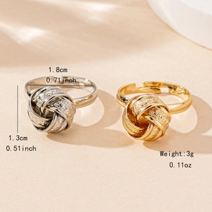 Adjustable twisted knot rings in gold and silver with textured finish on beige background