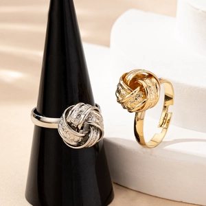 Twisted knot ring set in gold and silver with textured finish and adjustable open band