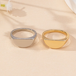 Detail of gold and silver geometric semi-circle signet rings on textured background