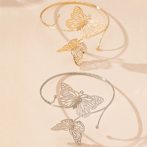 Gros plan détaillé des bracelets de bras papillon en finitions or et argent ciselés