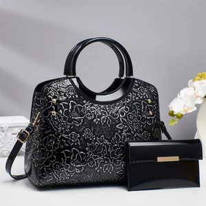 Glossy black Chinese style handbag set with floral embossing and round handles