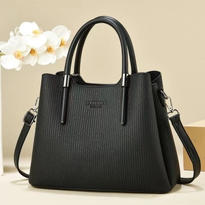 Detail der schwarzen Handtasche mit Plissee-Struktur und Fashion Queen Schriftzug