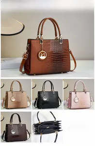 Detailed view of lizard pattern tote bag showing internal compartments and metal charm