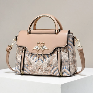 Fashionable graffiti tassel handbag with colorful patterns and swan lock on stone surface