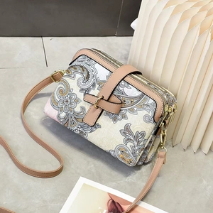 Détails du motif cachemire vintage sur le sac bandoulière beige et finitions dorées
