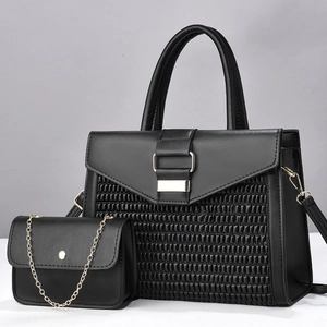 Detail of black woven texture tote bag with matching mini gold chain flap handbag set