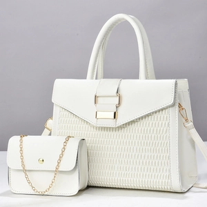 Detail of white woven handbag set featuring large tote and mini chain bag with gold hardware