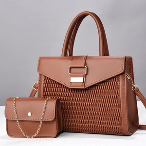 Detail of brown woven faux leather handbag set with gold hardware and small chain bag