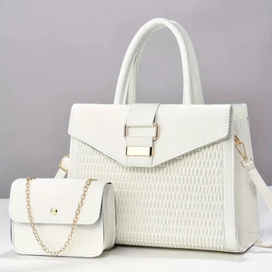 Detail of white tote bag set with woven texture finish and gold chain crossbody pouch
