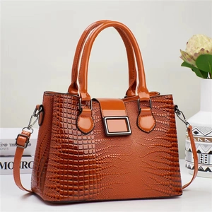 Vue détaillée du sac à main en cuir verni caramel avec texture lézard et boucle en métal