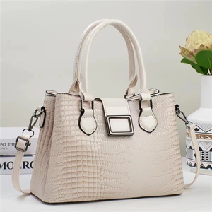 Détail du sac à main crème texturé lézard avec fermoir métallique et bandoulière