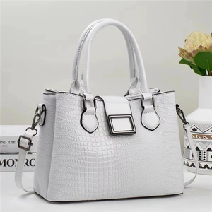 Détail du sac à main blanc à motif lézard avec fermoir métallique et finitions soignées