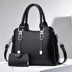 Close-up of black pebbled leather tote bag with matching coin purse and silver hardware