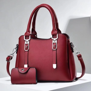 Close-up of wine red pebble leather handbag set with silver hardware and shoulder strap