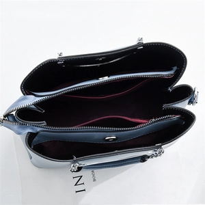 Detailed interior of blue chain bag showing three compartments and dark red lining