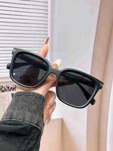 Close-up of matte black square sunglasses with silver temple accents and detailed specs