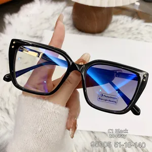 Detail of black cat-eye glasses with photochromic blue light blocking lenses and gold metal temples
