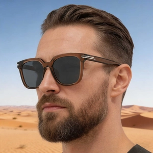 Fashion square tea-colored sunglasses with gray lenses worn by a male model in desert