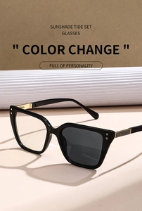 Detail of photochromic cat-eye sunglasses showing color-changing lenses and gold hinges