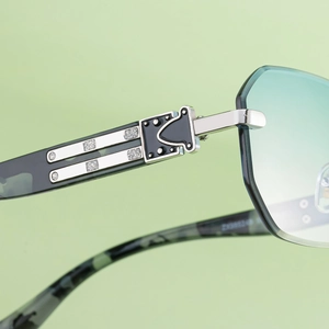 Close-up of silver metal hinge with black enamel and rhinestones on square sunglasses