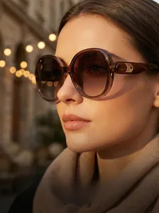 Close-up of oversized square sunglasses with amber frames and gold metal hinge details