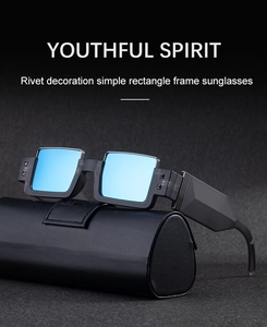 Detail of black rectangular sunglasses with rivets and blue reflective lenses on a case