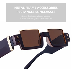 Detailed close-up of rectangle sunglasses featuring golden pyramid rivets on black frames