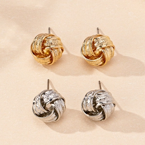 Detailed view of woven love knot stud earrings in gold and silver finish with textured surface