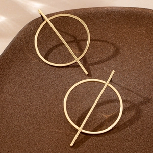 Minimalist gold geometric circle earrings with straight bar design on ceramic bowl
