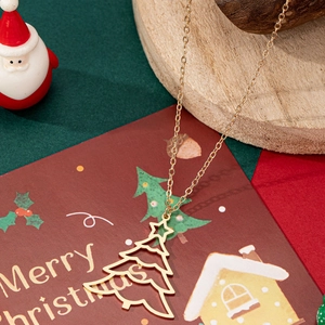 Collier avec pendentif sapin de Noël évidé doré sur un présentoir de fête élégant