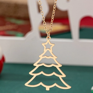 Collier pendentif sapin de Noël doré ajouré avec étoile sur un fond de fête