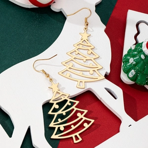 Detail shot of gold hollow Christmas tree earrings with star charm on festive background