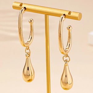Elegante goldene Tropfenohrringe mit Hochglanz-Finish auf einem minimalistischen T-Ständer