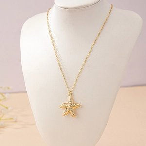 Elegant gold starfish pendant necklace displayed on a white neck bust for a beach vacation