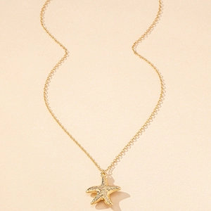 Detailed view of golden starfish pendant with intricate textured surface on a link chain