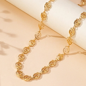 Cintura a catena dorata con maglie a spirale e motivo a rosa su supporto neutro