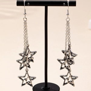 Elegant vintage silver tassel star earrings hanging on a black jewelry stand display