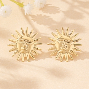 Detail shot of sun face stud earrings in gold finish with intricate radiant ray textures