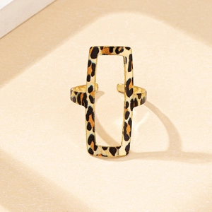 Detailed view of an open rectangular ring with gold finish and leopard print pattern