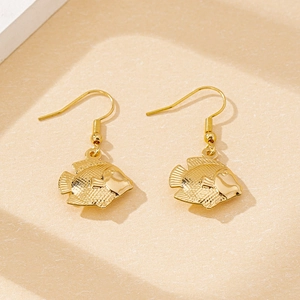 Macro shot of gold fish-shaped drop earrings with intricate scale and fin details