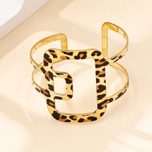 Gros plan du bracelet manchette ajouré doré avec motif léopard et design géométrique