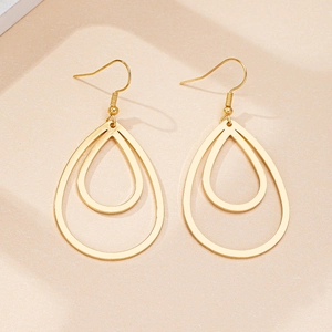 Detail of gold double-layer hollow teardrop earrings with polished finish and fishhooks