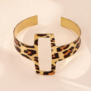 Détail d'un bracelet jonc doré avec imprimé léopard et design géométrique ajouré