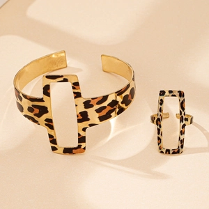 Macro view of golden hollow geometric leopard print cuff bracelet and adjustable ring set