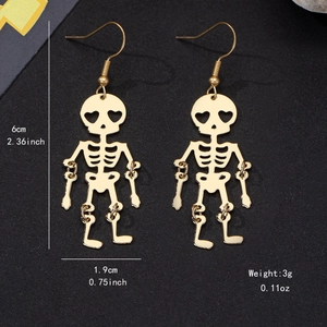 Golden skeleton earrings with heart eyes and size measurements on black background