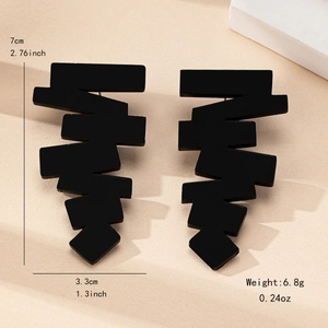 Orecchini geometrici neri opachi con design a gradini su supporto minimalista chic