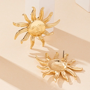 Fashionable gold sun face stud earrings on a geometric beige background stand