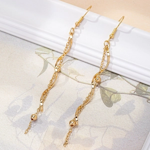Boucles d'oreilles pendantes dorées avec longs glands et perles sur cadre vintage